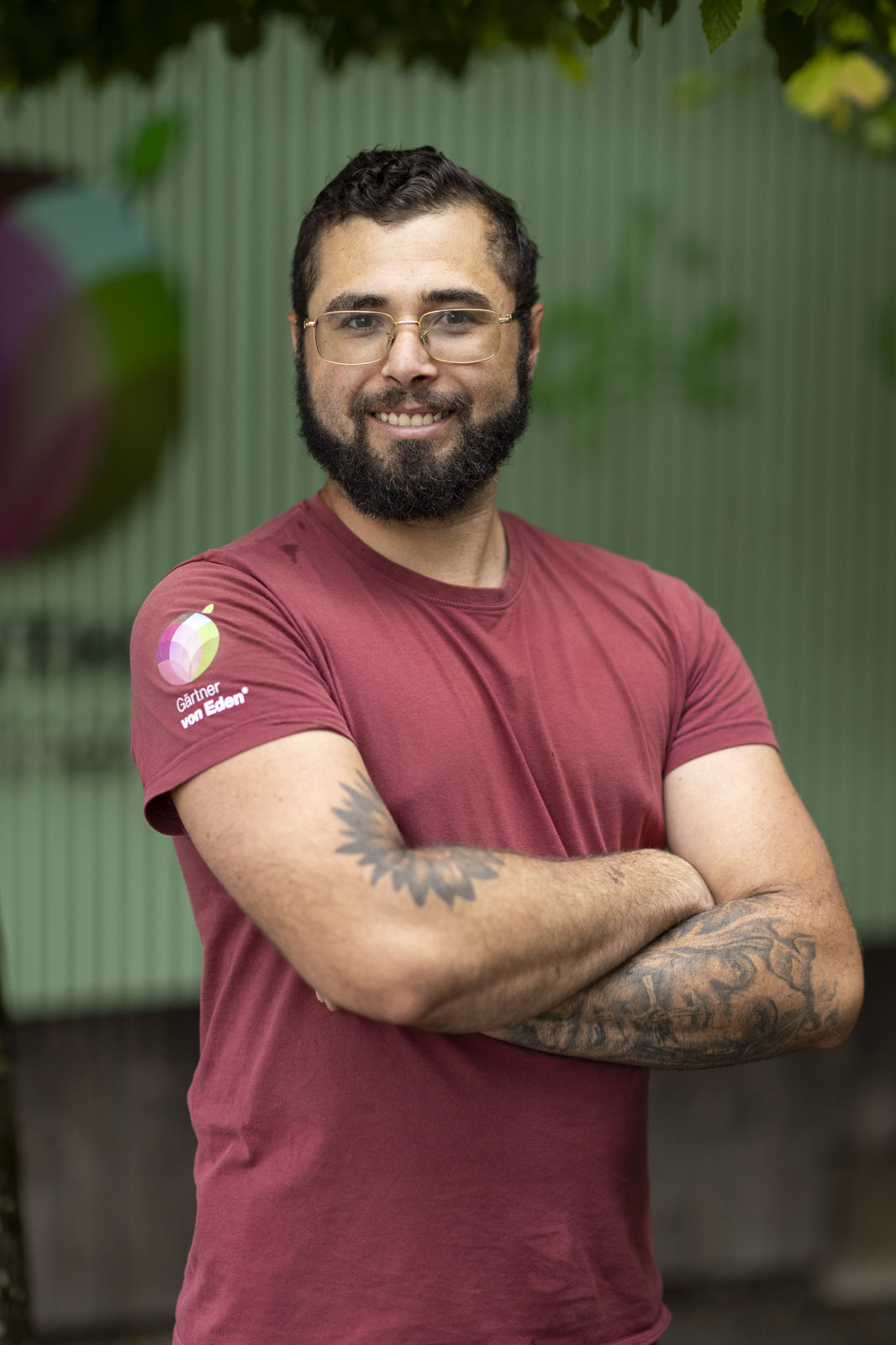 Matheus Izidoro mit verschränkten Armen im burgunderroten Shirt, Garten von Eden Matheus Izidoro; Team Gartenliebhaber, Gärtner von Eden