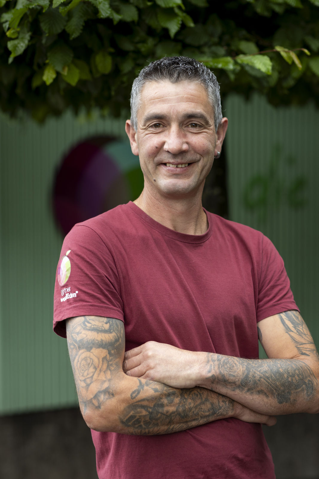 Paulo Rocha mit tätowierten Armen vor grünem Hintergrund Paulo Rocha; Team Gartenliebhaber, Gärtner von Eden